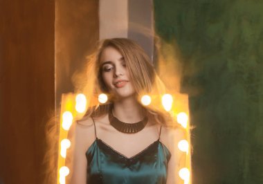 Karışık ışık tekniğinde poz elbiseli çekici sarışın model