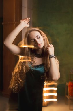 Zarif genç kadın karışık ışığıyla karanlık odada dans