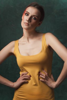 Güzel genç esmer model parlak makyaj gree üzerinde poz ile