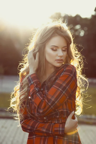 Sensual young model with closed eyes in checkered dress in rays — Stock Photo, Image