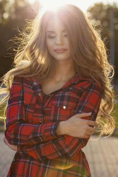 Inschrijving jonge vrouw met gesloten ogen in geruite jurk in stralen o — Stockfoto