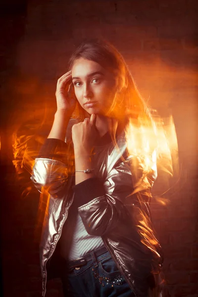 Genç esmer bir model parlak gümüş ceket kot. Mixe