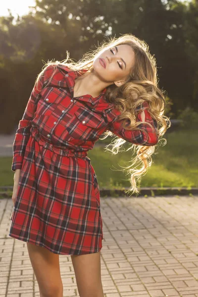 Hermosa modelo joven con el pelo ondulado exuberante en checkere de moda —  Fotos de Stock