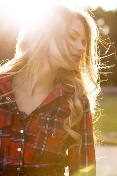 Modelo loira sensual com cabelo ondulado longo em xadrez vestido posi — Fotografia de Stock