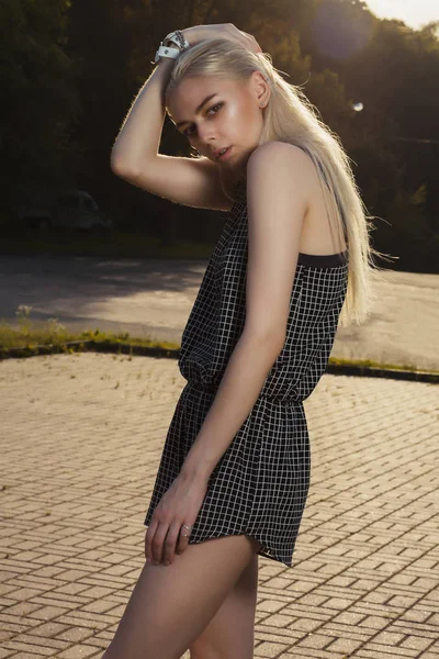 Sexy loira modelo em preto romper posando no parque em ensolarado da — Fotografia de Stock