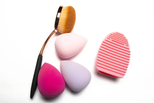 Oval brush and beauty blenders with brush cleaner on a white bac — Stock Photo, Image