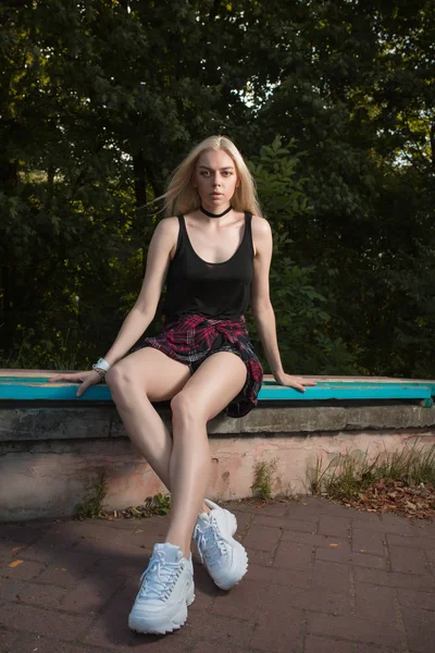 Sarışın modelde şık moda giyim bir Bank üzerinde poz