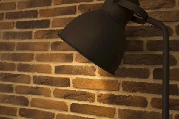 Old style desk lamp on a background of brick wall