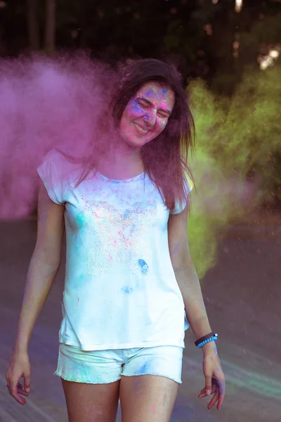 Mujer joven sonriente en la naturaleza cubierta de colorido polvo Gulal — Foto de Stock