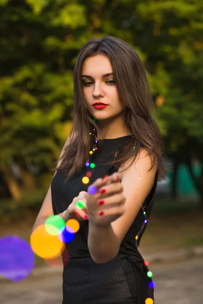 Güzel ve genç birbayan holding garland parkta — Stok fotoğraf