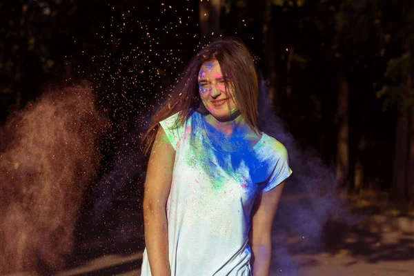 Renkli Holi ile kaplı uzun saçlı esmer modeli gülümseyen