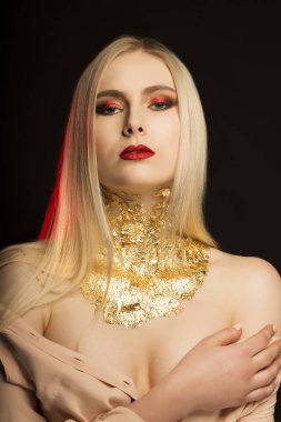 Uzun sarı saçlı ve altın genç modelinin moda portre