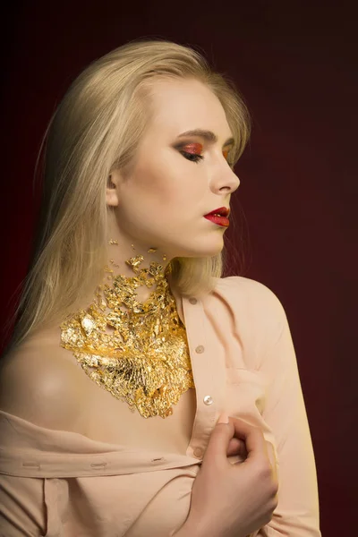 Modelo sensual com cabelo loiro longo e padrões de folha dourada — Fotografia de Stock