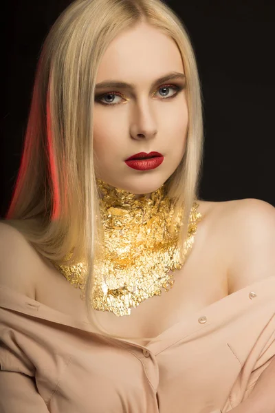 Elegant ung modell med långa blonda hår och gyllene folie på henne — Stockfoto