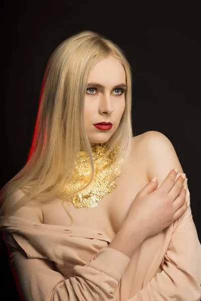 Luxo modelo jovem com cabelo loiro longo e folha dourada em sua — Fotografia de Stock