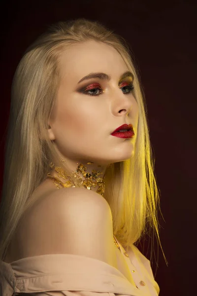 Attraktive junge Frau mit langen blonden Haaren und gol-Muster — Stockfoto