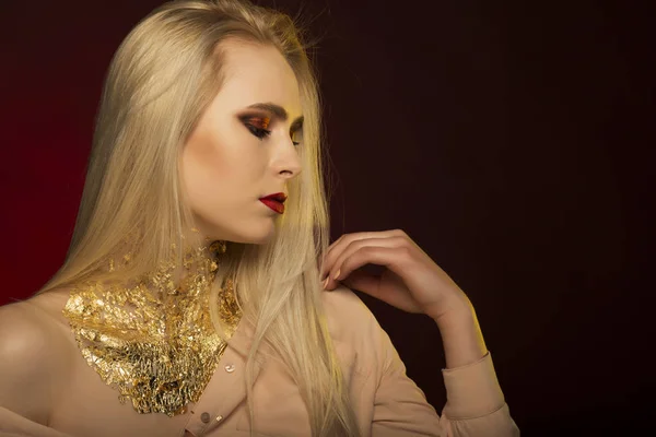 Mooie jonge model met lang blond haar en gouden folie op haar — Stockfoto