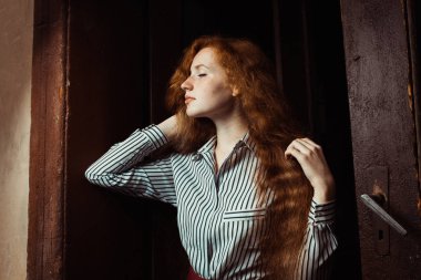 Şehvetli genç kırmızı saçlı modeli uzun gür saçlı. Kadın poz