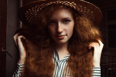 Güzel genç kırmızı saçlı model hasır şapka po kıvırcık saçlı