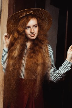 Güzel genç kırmızı saçlı modeli ile hasır şapka poz içinde çiller 