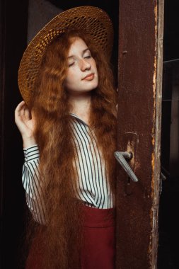 Hasır şapka p uzun dalgalı saçlı genç ve güzel kırmızı saçlı modeli