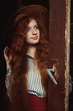 Hasır şapka poz içinde çiller ile zarif genç kırmızı saçlı modeli