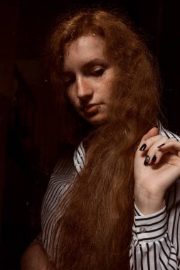 Genç kırmızı saçlı modeli ile kapalı bir g arkasında duran uzun saç