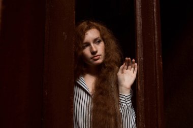 İhale kırmızı saçlı model ayakta kapalı cam kapının arkasında. Rai