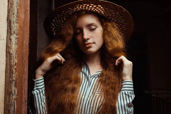 Pályázati vörös hajú modell, csukott szemmel, szalma kalapban pózol pas — Stock Fotó