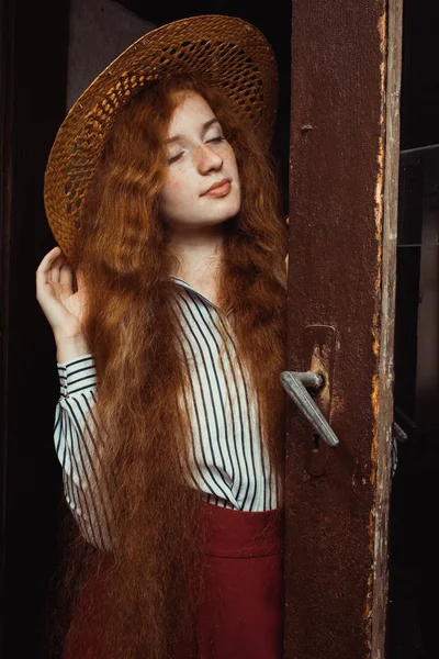 Hasır şapka p uzun dalgalı saçlı genç ve güzel kırmızı saçlı modeli