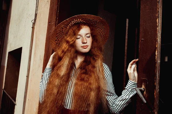 Güzel kızıl saçlı model kapalı gözlerinin içine hasır şapka pas içinde poz ile