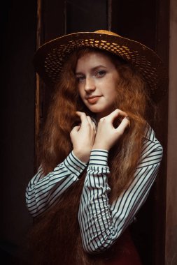 Ben poz hasır şapkalı uzun kıvırcık saç modeliyle şehvetli redhead