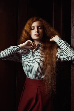 Şehvetli genç kırmızı saçlı modeli uzun gür saçlı. Kadın poz