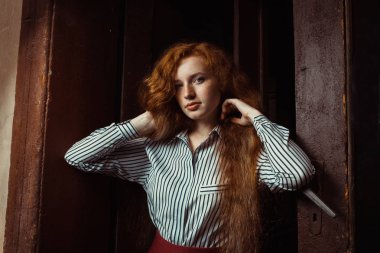 Görkemli kırmızı saçlı modeli uzun gür saçlı. Kadın poz bir