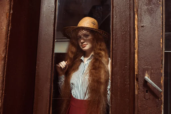 Elegantes junges rothaariges Model mit Strohhut und Schatten auf dem Kopf — Stockfoto