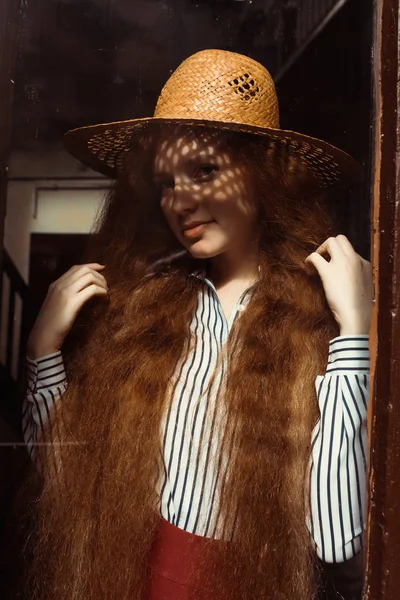 Hübsche junge rothaarige Frau mit Strohhut und Schatten auf dem Kopf — Stockfoto