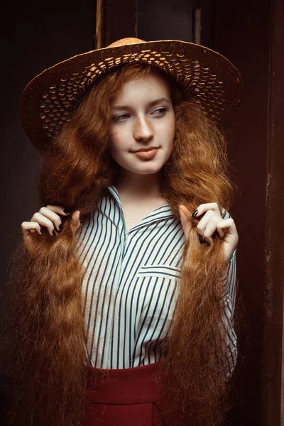 Pretty redhead woman with long curly hair in straw hat posing ne — Stock Photo, Image