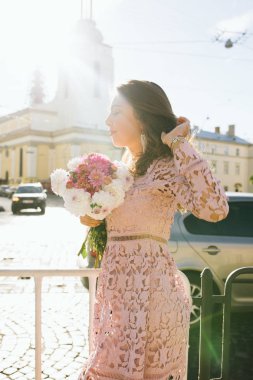 Genç ve güzel buket çiçek tutan dantel elbise modeli
