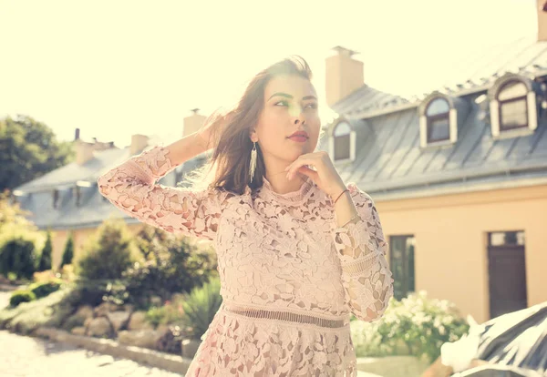 Sihir genç kadında dantel elbise, cadde ışınları olarak poz
