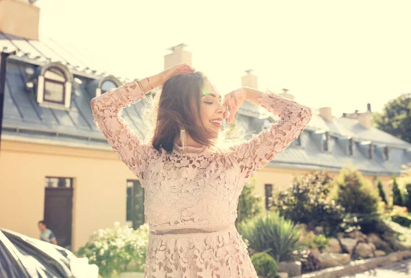 Çok gülümseyen modeli dantel elbise, cadde ışınları olarak poz 