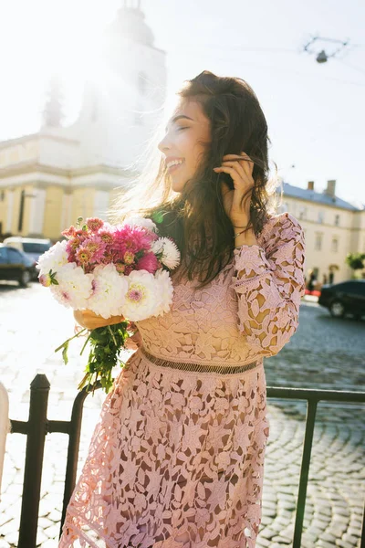 Υπέροχη χαμογελαστή μοντέλο φόρεμα απο δαντέλα που κρατάει μπουκέτο λουλούδια — Φωτογραφία Αρχείου