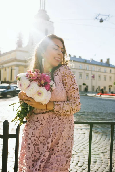 Modisches lächelndes Model im Spitzenkleid mit Blumenstrauß — Stockfoto