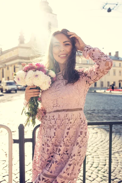 Glücklich brünette Frau im trendigen Kleid posiert auf der Straße mit s — Stockfoto