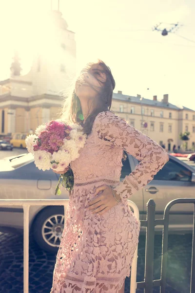 Atractiva joven dama en vestido de moda posando en la calle con — Foto de Stock