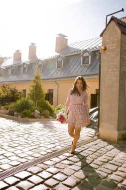 Bir buket çiçek t yürüyüş ile çekici esmer modeli