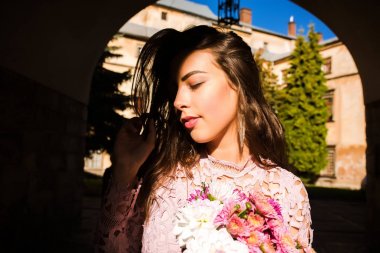 Buket çiçek tutan çekici genç model. Kadın poz 