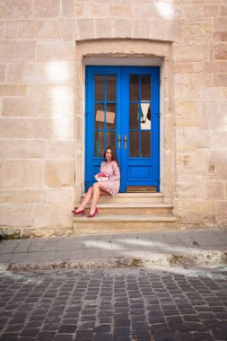 Havalı elbiseler içinde güzel esmer manken elinde fl buketi tutuyor.