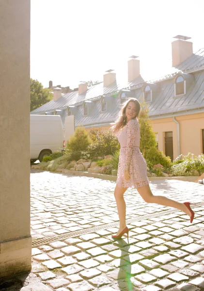 Mutlu esmer modeli cadde boyunca güneşli sabah çalışır.