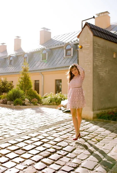 Cadde boyunca güneşli sabah yürüyen genç ve güzel kadın