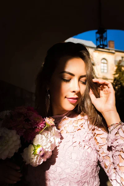 Beautiful young model holding bouquet of flowers. Woman posing a — Stock Photo, Image